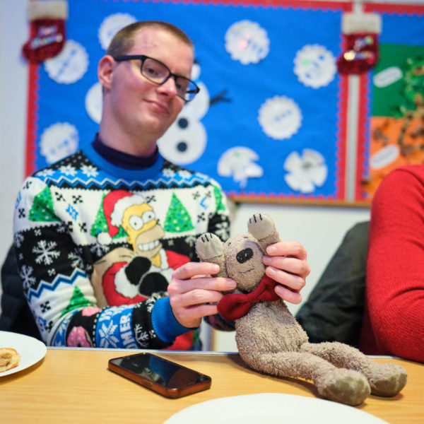 DSCF6027 A young person in a Simpsons Christmas jumper with a teddy bear.