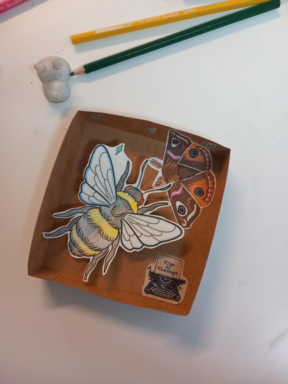 Media (19) A shallow box with a large paper bee, and a smaller butterfly and typewriter