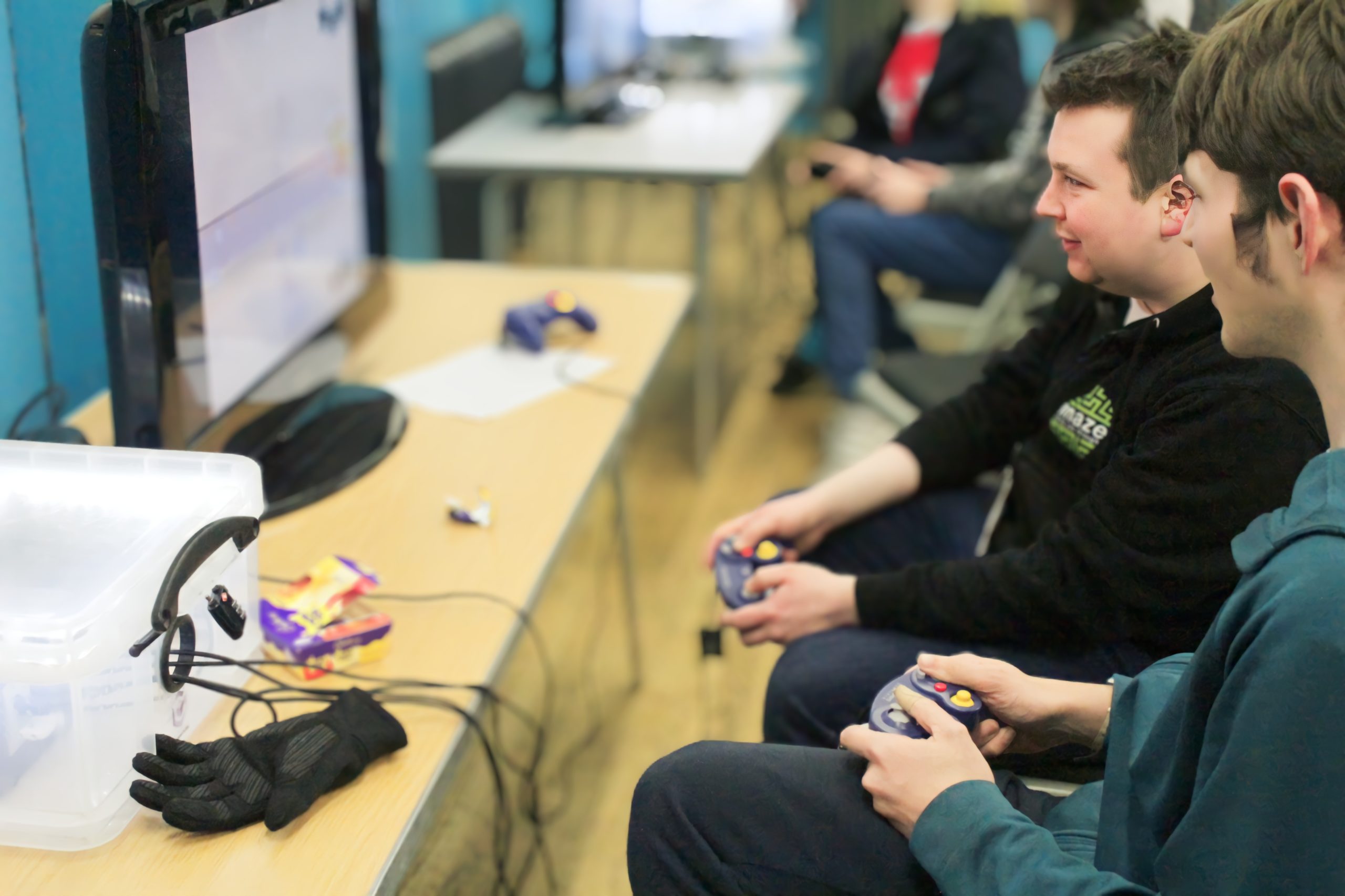 Mixed 4 Staff member playing retro console games with a young man.
