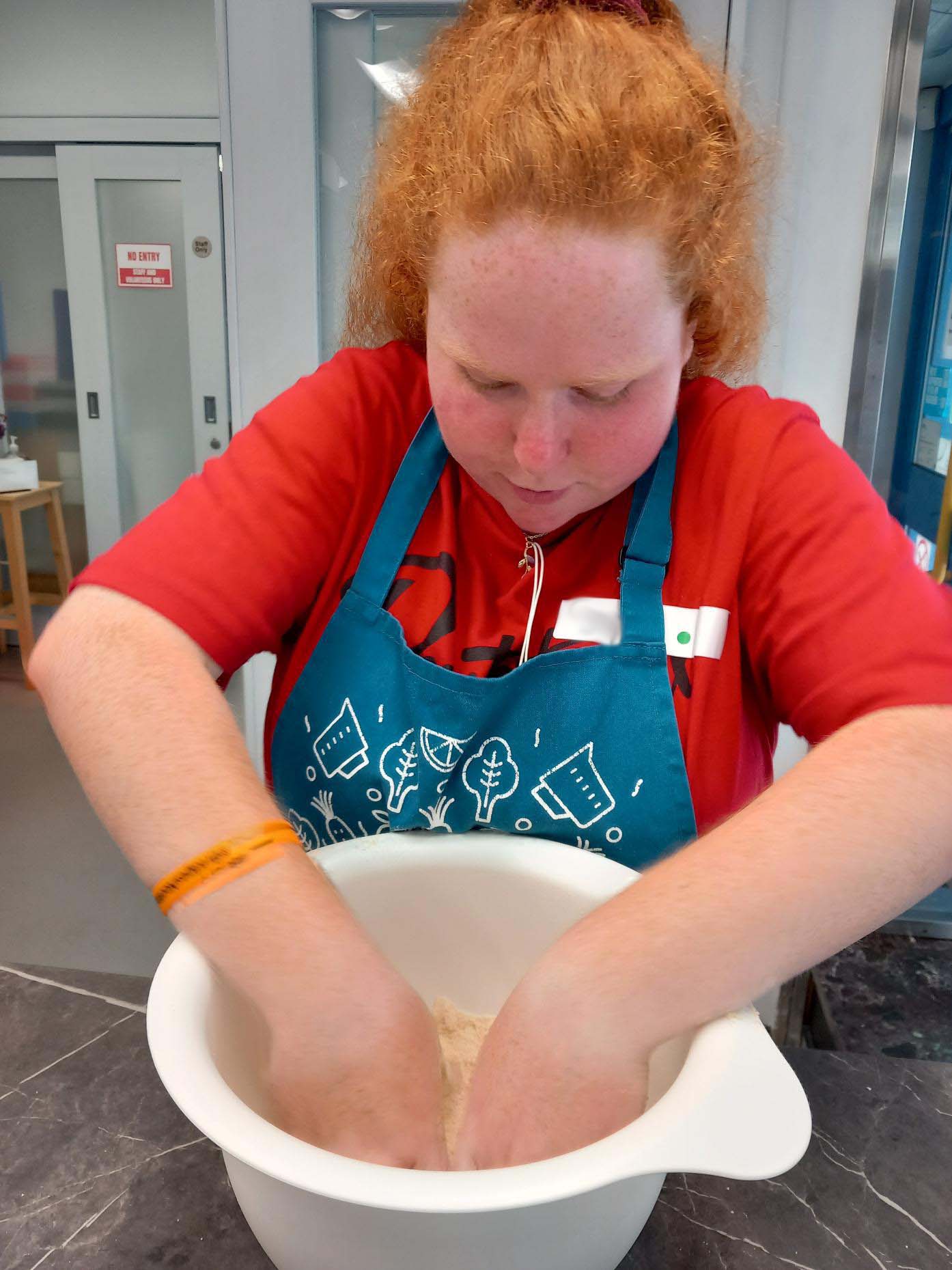 Young person mixing ingredients by hand at our baking session.