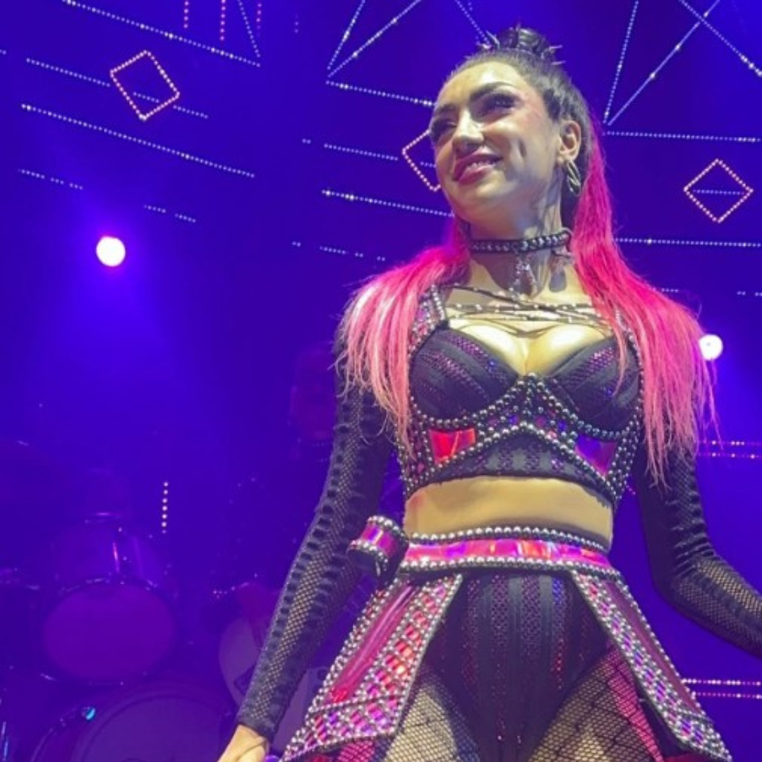 8 Actress with hot pink long hair, wearing a pink outfit with a bustier.