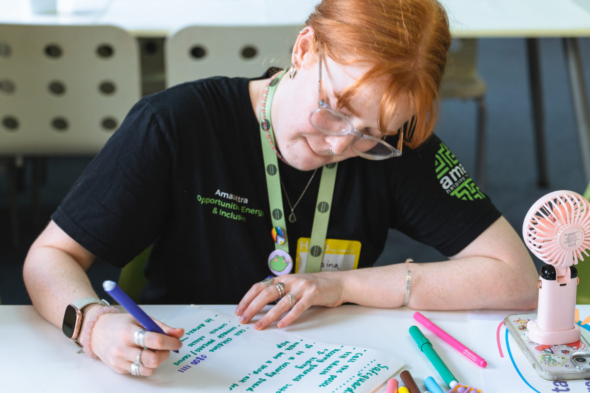Youth Worker, Elaina, writing on a piece of paper.