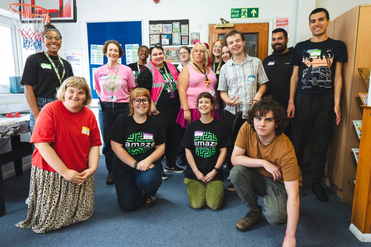 The Amazing Futures team poses for a photo along with some of the young people. Some people are kneeling at the front, while the rest stand behind.