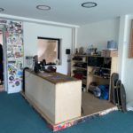 Reception area. There is a stack of skateboards, and lots of stickers on the walls.