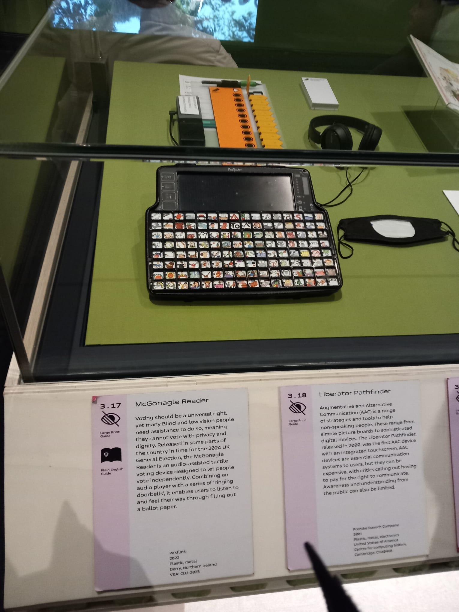 An adaptive device to allow Blind people to vote independently, called a McGonagle Reader. It has many small buttons, a small screen, and headphones.
