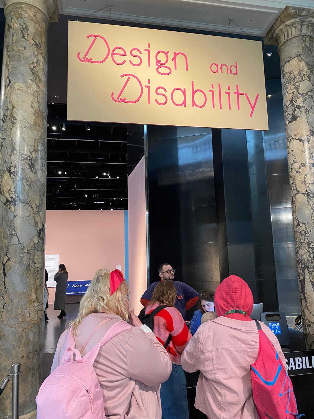 Young people entering exhibition below Design and Disability sign