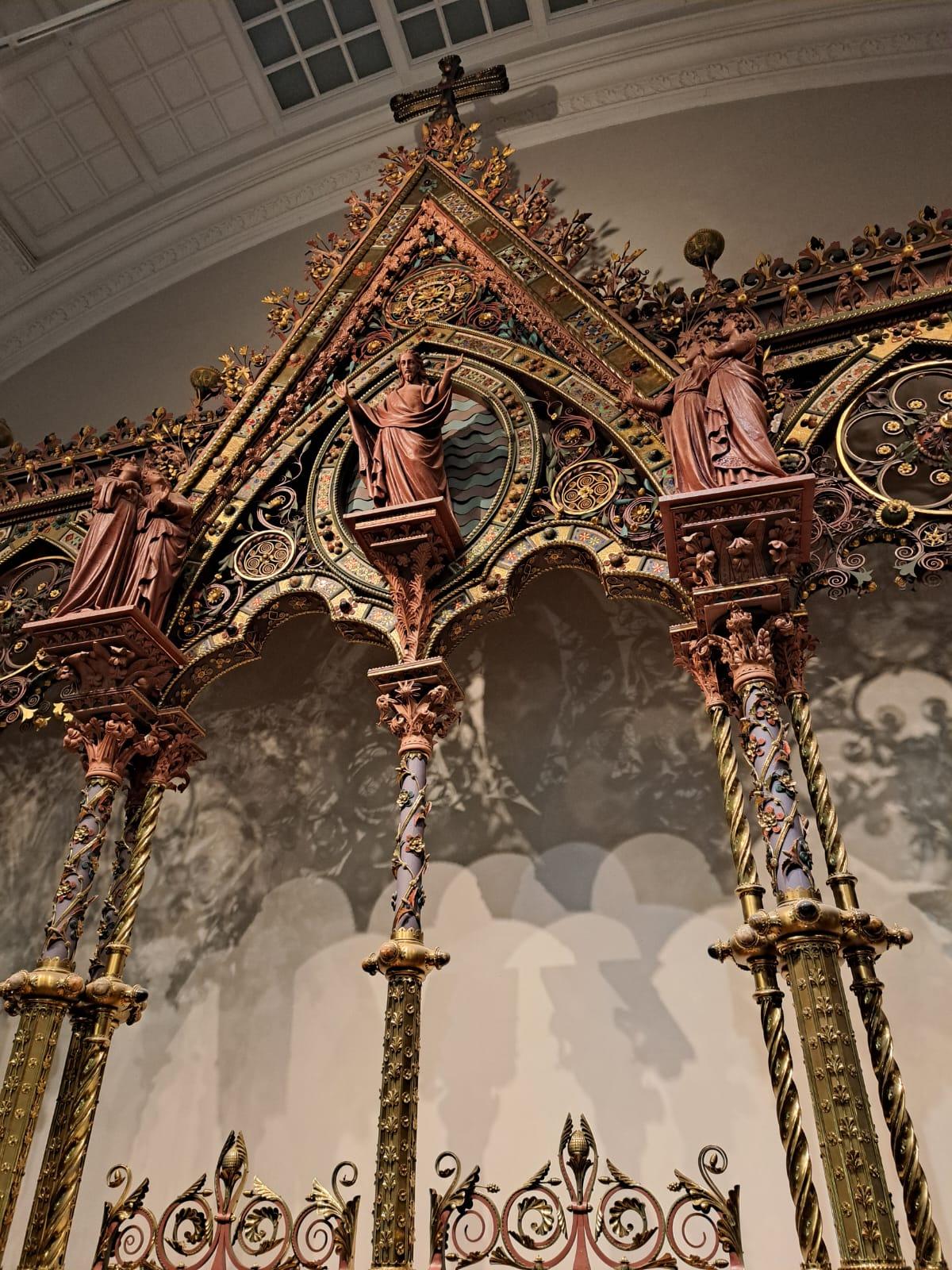Close-up on an intricate altar, featuring statues and columns.