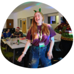 Laughing youth worker at a group session, young people in the background