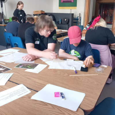 short breaks 2026 blog post images A youth worker helping a young person design a banner, in a workshop at Brighton Museum.