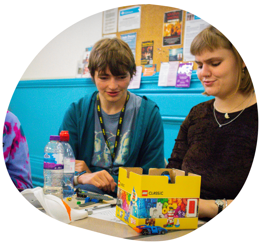 Volunteer and young person using lego together.